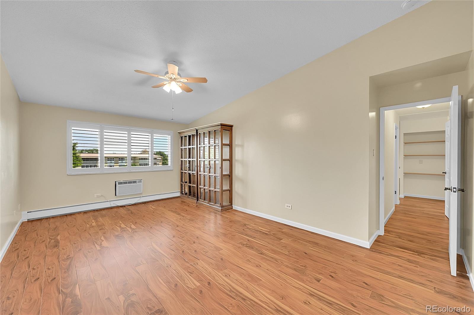 645 South Alton Way, Unit 9D Denver, CO 80247 - Photo 10 of 29 a view of an empty room with a window and wooden floor