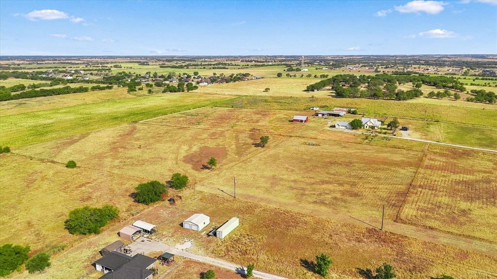 Tbd Cashs Mill Road Sanger, TX 76266 - Photo 6 of 21 Expansive rural property featuring multiple residential structures, outbuildings, a winding unpaved road, and diverse landscaping