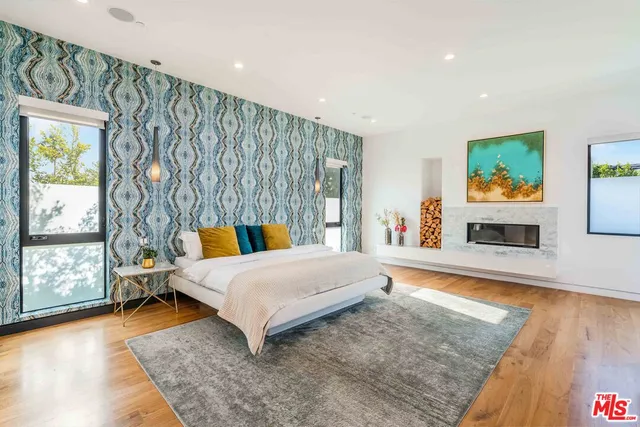 a bedroom with a bed a large window and couch