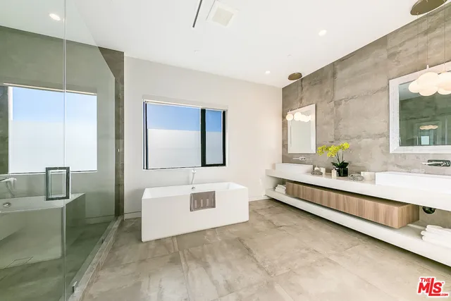 a large bathroom with a double vanity sink toilet mirror and bathtub