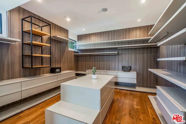 a bedroom with a bed and a flat tv screen on dresser