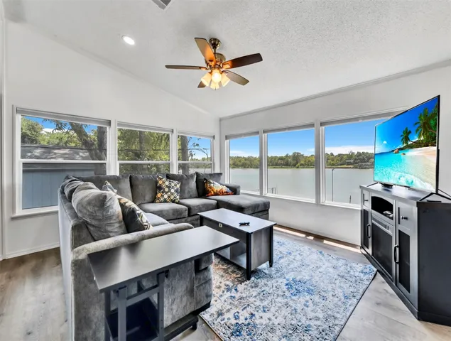 a living room with furniture a rug and a floor to ceiling window