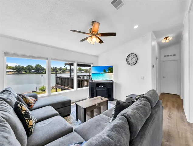 a living room with furniture ceiling fan and a window
