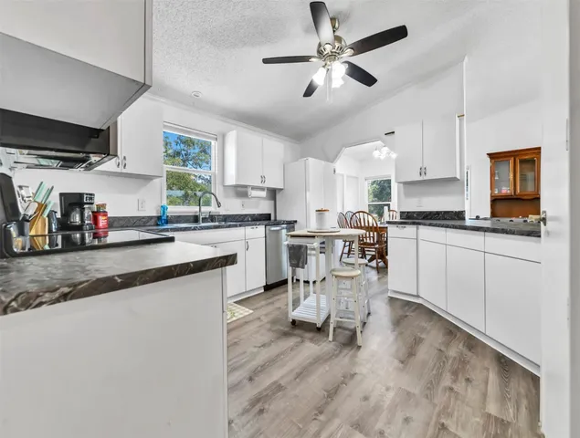 a kitchen with stainless steel appliances kitchen island granite countertop a sink a stove a dining table and chairs