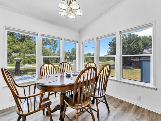 a outdoor dining space with furniture wooden floor and a chandelier