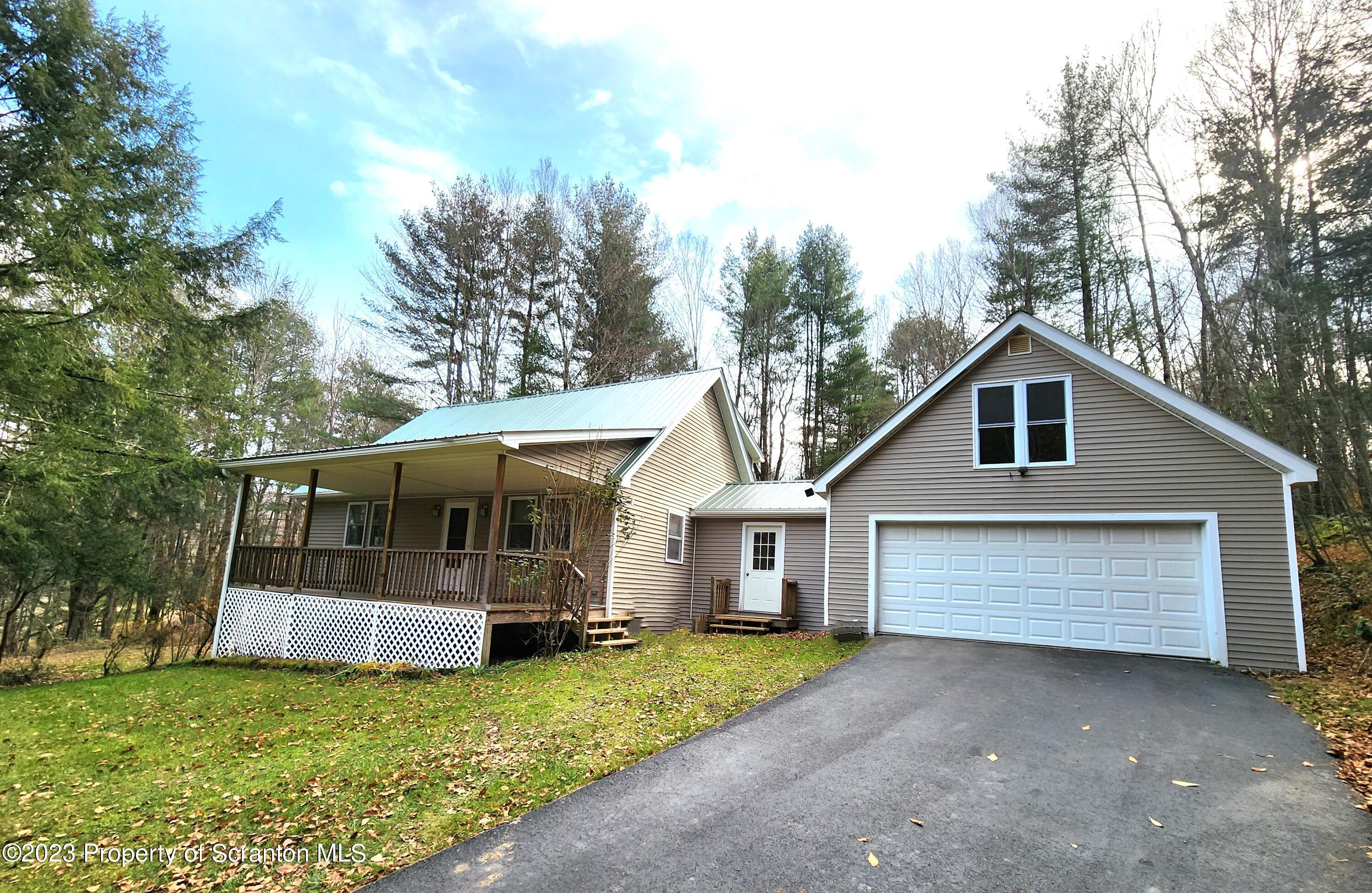 a view of a house with a yard and large tree