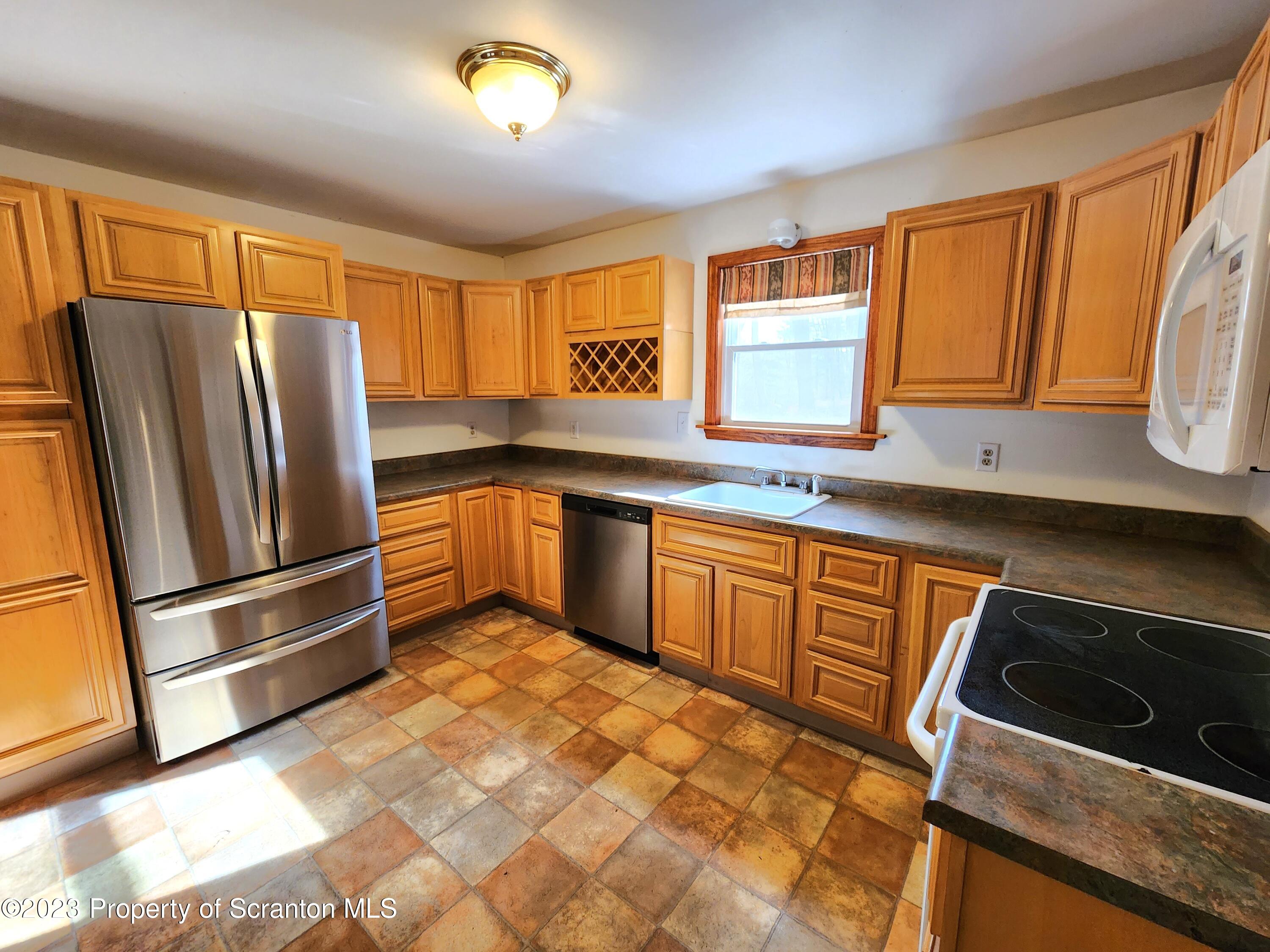 1575 State Rte 2009 Nicholson, PA 18446 - Photo 23 of 54 a kitchen with granite countertop stainless steel appliances a sink stove refrigerator and cabinets