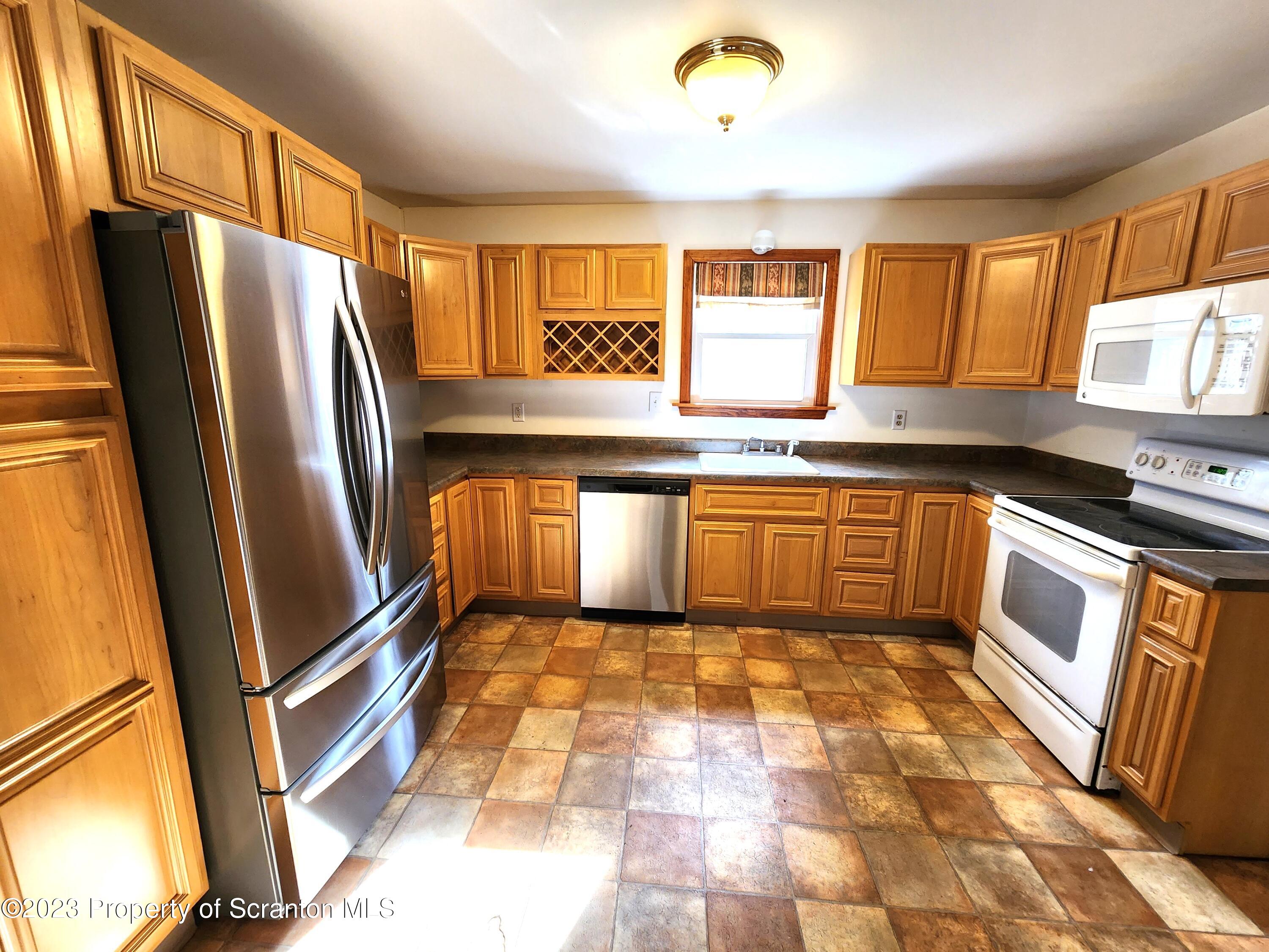 1575 State Rte 2009 Nicholson, PA 18446 - Photo 24 of 54 a kitchen with stainless steel appliances granite countertop a refrigerator a sink a stove top oven and a refrigerator