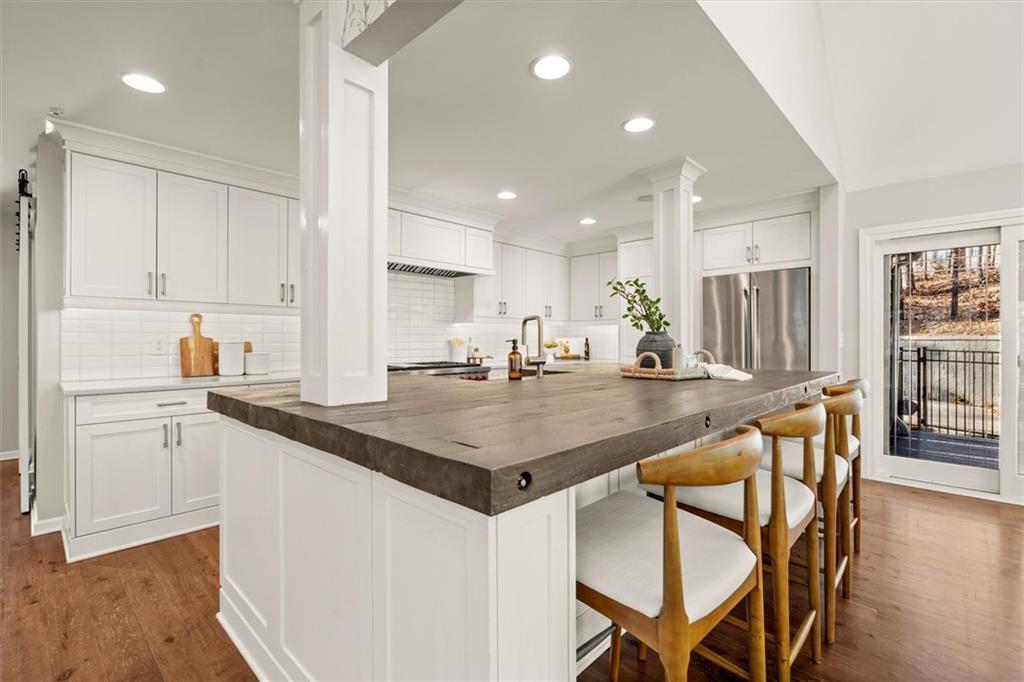 4367 Moss Ridge Court Northeast Roswell, GA 30075 - Photo 22 of 84 a kitchen with stainless steel appliances granite countertop a table chairs sink and cabinets