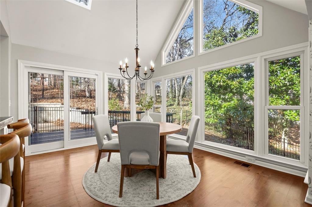 4367 Moss Ridge Court Northeast Roswell, GA 30075 - Photo 27 of 84 a dining room with wooden floor a chandelier a glass table and chairs