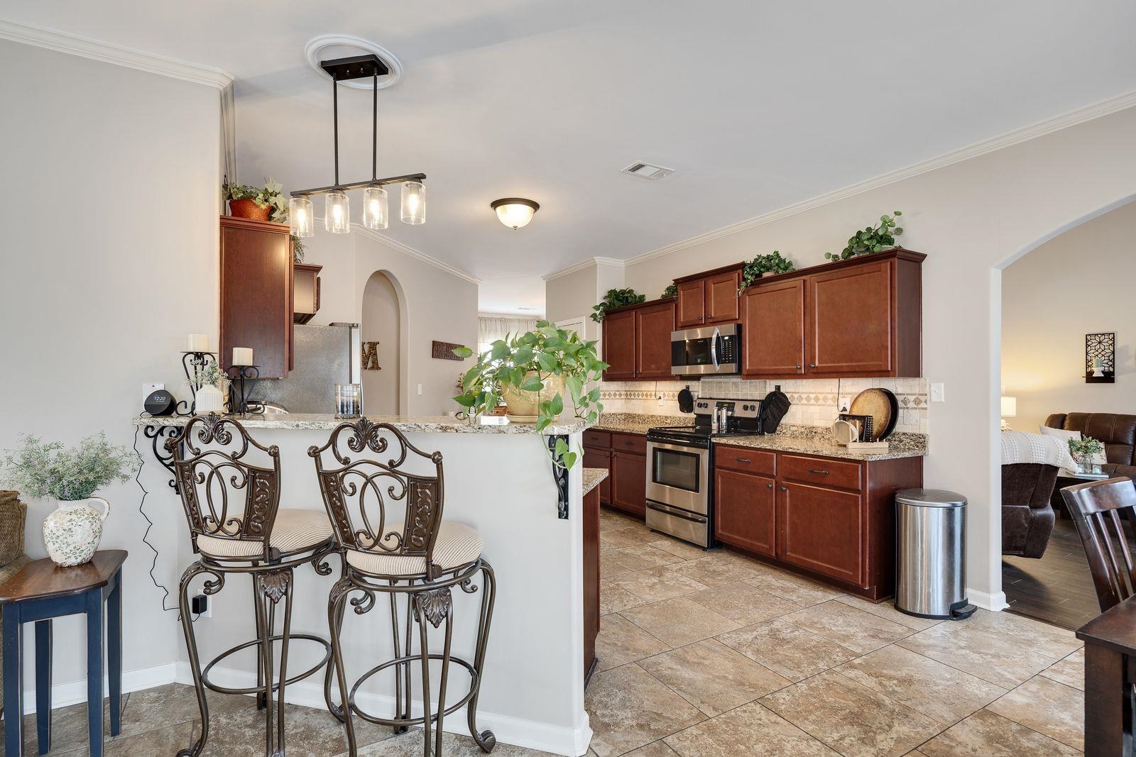 6247 Willow Walk Way Arlington, TN 38002 - Photo 14 of 40 a kitchen with stainless steel appliances kitchen island granite countertop a table chairs and a refrigerator