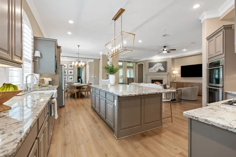 a kitchen with stainless steel appliances granite countertop a lot of cabinets and wooden floor