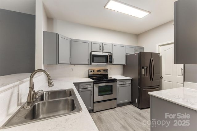 a kitchen with a refrigerator sink and stainless steel appliances