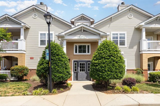 a view of a house with a yard and potted plants