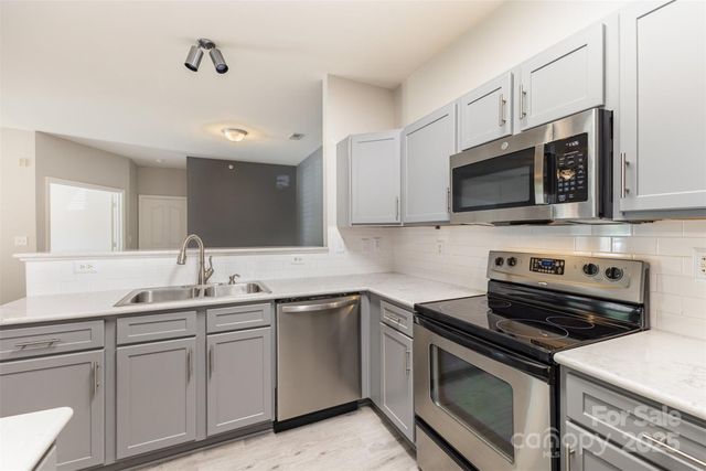 a kitchen with a sink stove and microwave