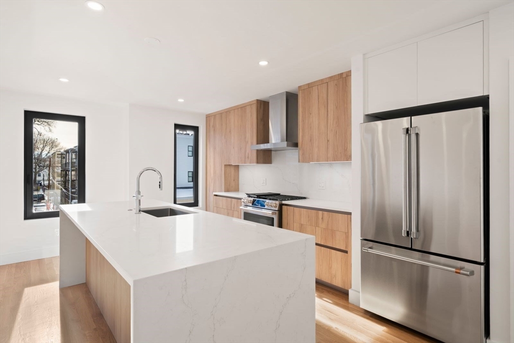 6 Devine Way, Unit 2 Boston, MA 02127 - Photo 11 of 39 a kitchen with stainless steel appliances a refrigerator sink and stove