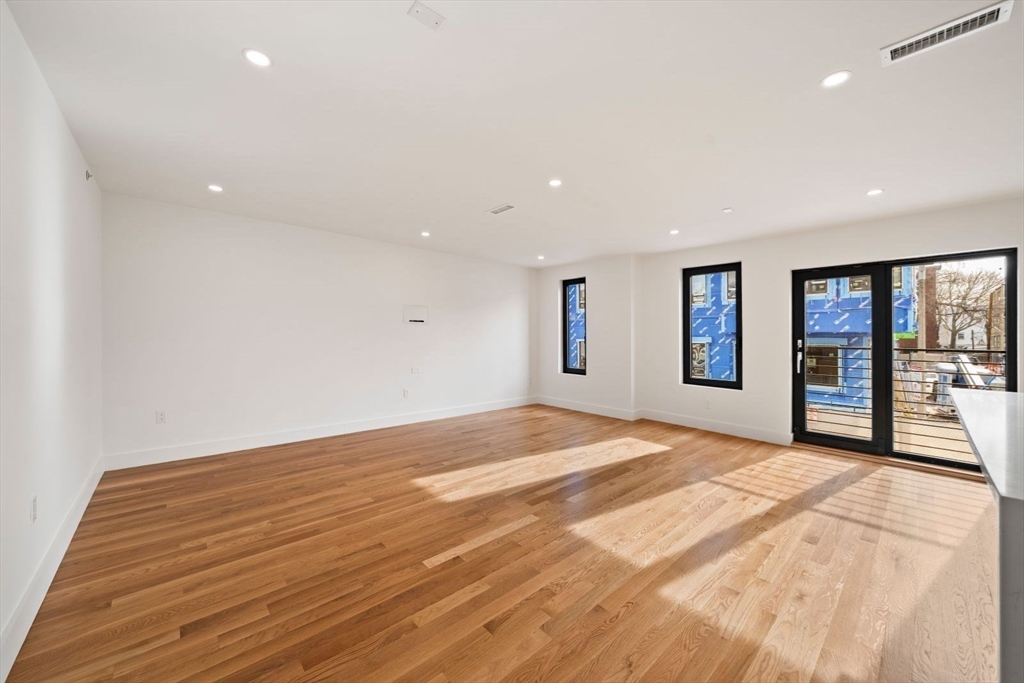6 Devine Way, Unit 2 Boston, MA 02127 - Photo 14 of 39 a view of an empty room with wooden floor and a window