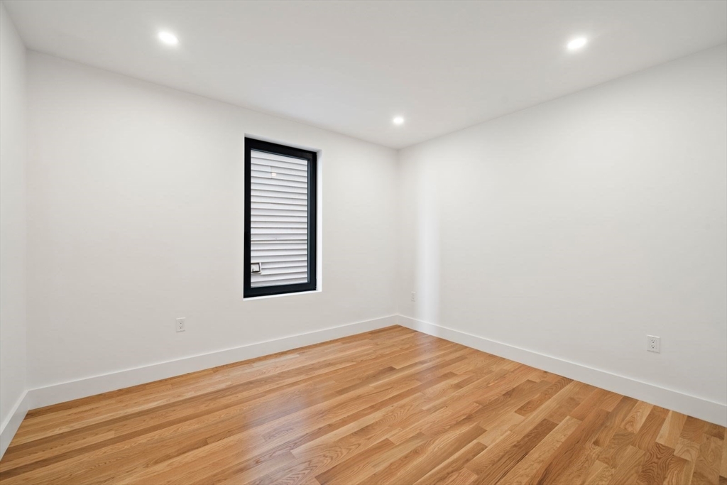 6 Devine Way, Unit 2 Boston, MA 02127 - Photo 21 of 39 an empty room with wooden floor and windows