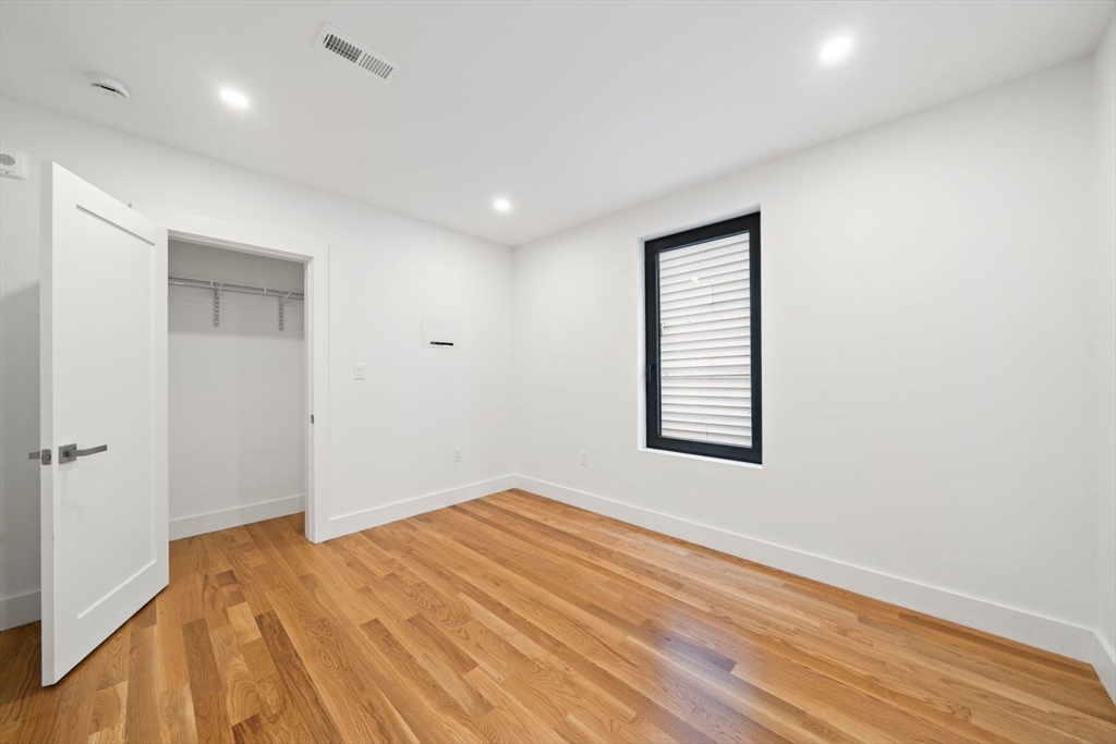 6 Devine Way, Unit 2 Boston, MA 02127 - Photo 22 of 39 an empty room with wooden floor and windows
