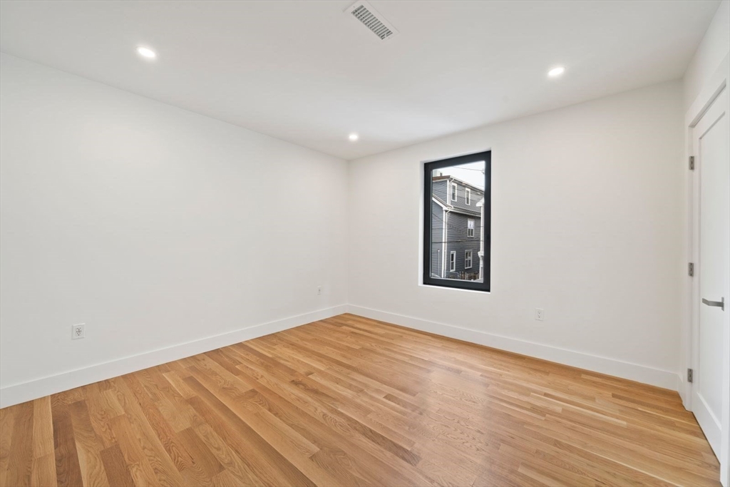 6 Devine Way, Unit 2 Boston, MA 02127 - Photo 26 of 39 a view of an empty room with wooden floor and a window