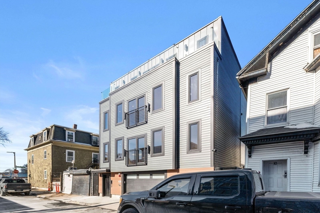 6 Devine Way, Unit 2 Boston, MA 02127 - Photo 36 of 39 a front view of a building with lot of cars and trees