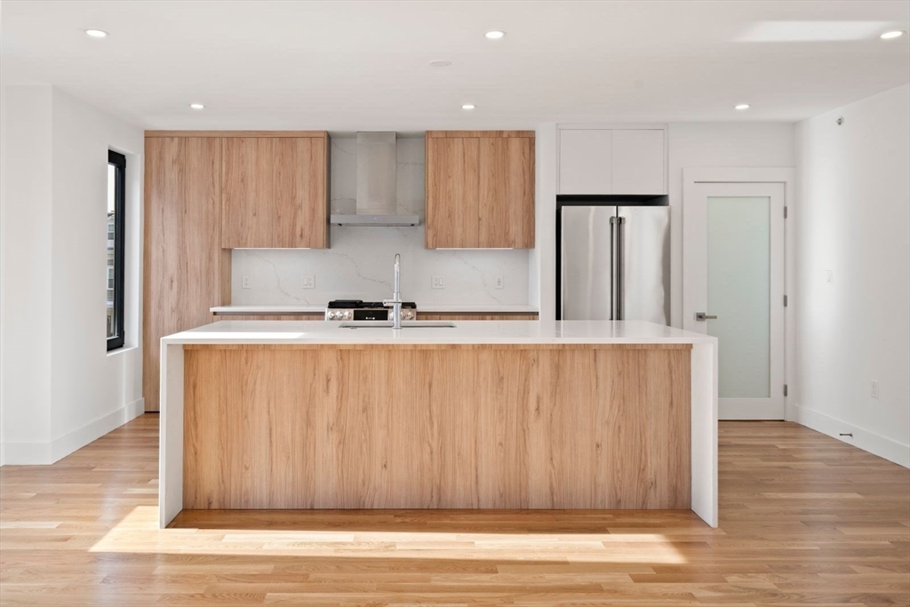 6 Devine Way, Unit 2 Boston, MA 02127 - Photo 5 of 39 a kitchen with wooden cabinets and stainless steel appliances