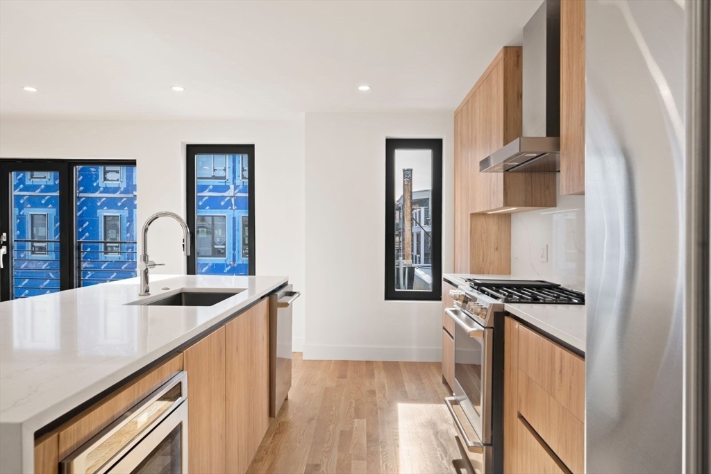 6 Devine Way, Unit 2 Boston, MA 02127 - Photo 8 of 39 a kitchen with stainless steel appliances granite countertop a sink and a stove