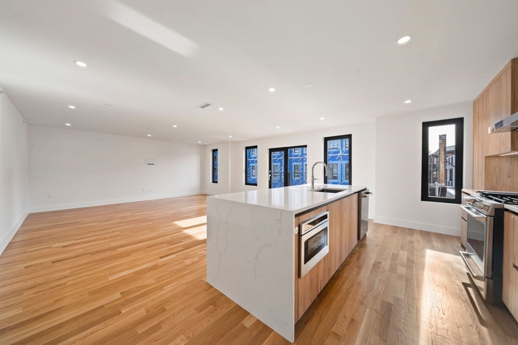 6 Devine Way, Unit 2 Boston, MA 02127 - Photo 9 of 39 a kitchen with stainless steel appliances granite countertop a stove and a sink