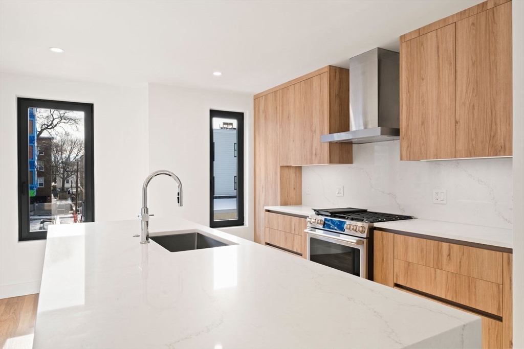 6 Devine Way, Unit 2 Boston, MA 02127 - Photo 10 of 39 a kitchen with granite countertop a stove a sink and a refrigerator