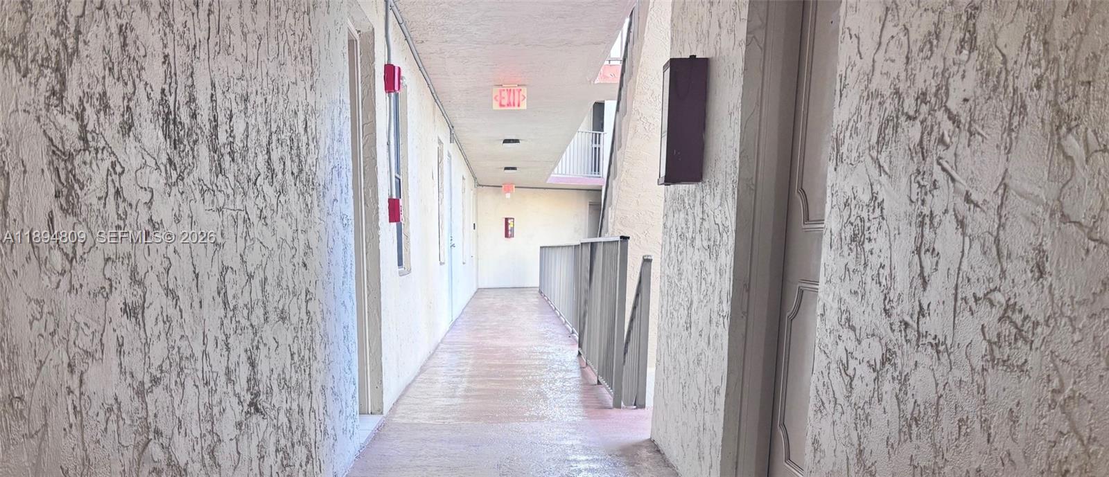8050 West McNab Road, Unit 212 Tamarac, FL 33321 - Photo 13 of 19 a hallway with a white door and a wooden floor