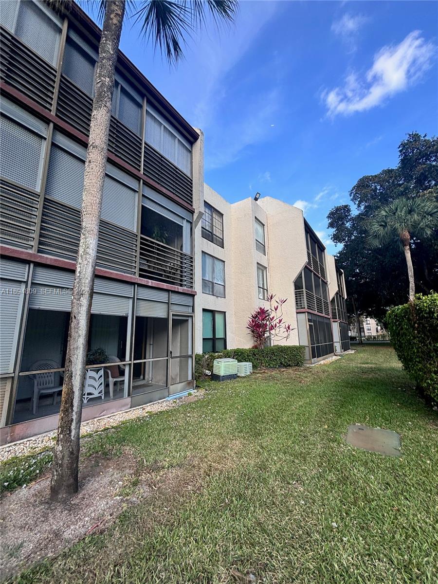 8050 West McNab Road, Unit 212 Tamarac, FL 33321 - Photo 16 of 19 front view of house with a yard