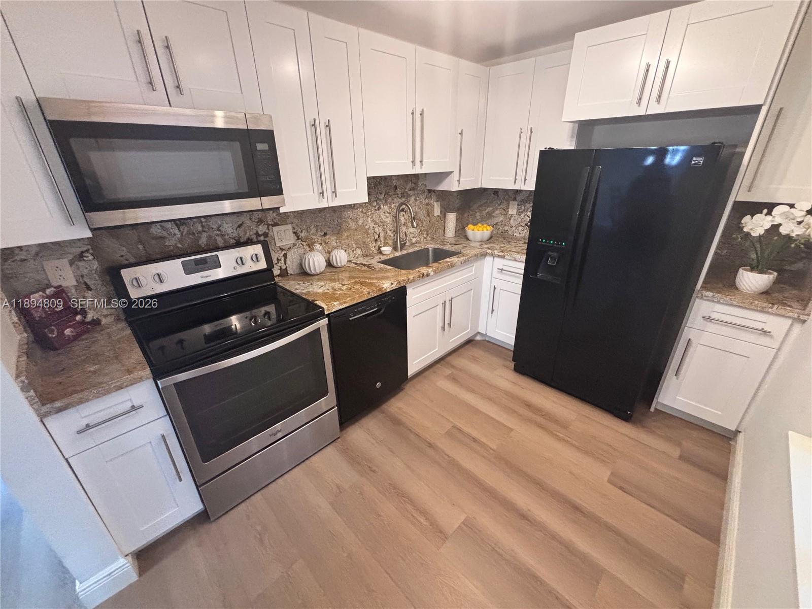 8050 West McNab Road, Unit 212 Tamarac, FL 33321 - Photo 5 of 19 a kitchen with a refrigerator stove and microwave