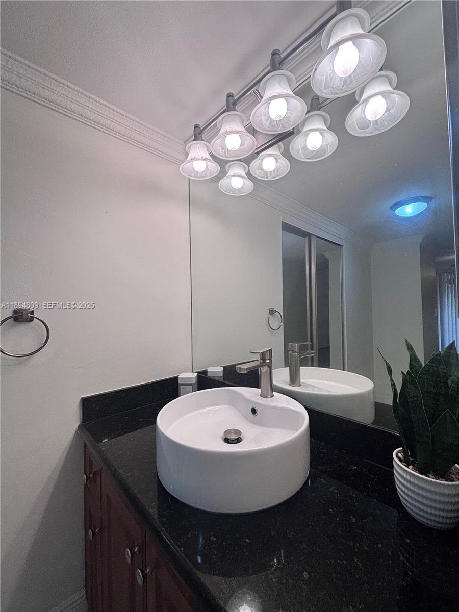 8050 West McNab Road, Unit 212 Tamarac, FL 33321 - Photo 8 of 19 a bathroom with a sink and a mirror