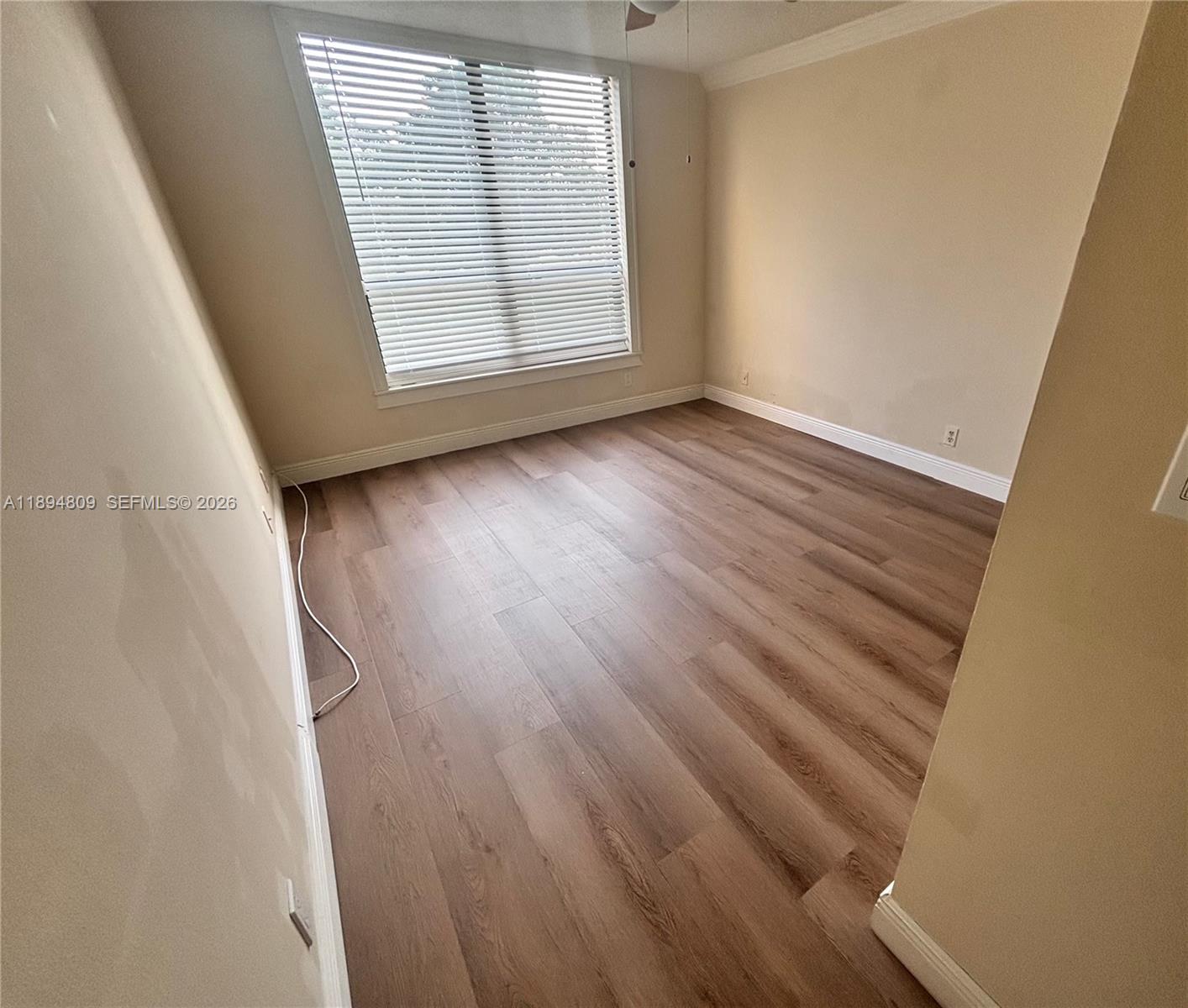 8050 West McNab Road, Unit 212 Tamarac, FL 33321 - Photo 10 of 19 an empty room with wooden floor and windows