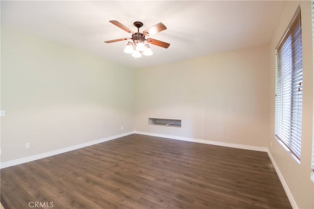 39705 Primrose Circle Murrieta, CA 92563 - Photo 13 of 31 an empty room with wooden floor chandelier fan and windows