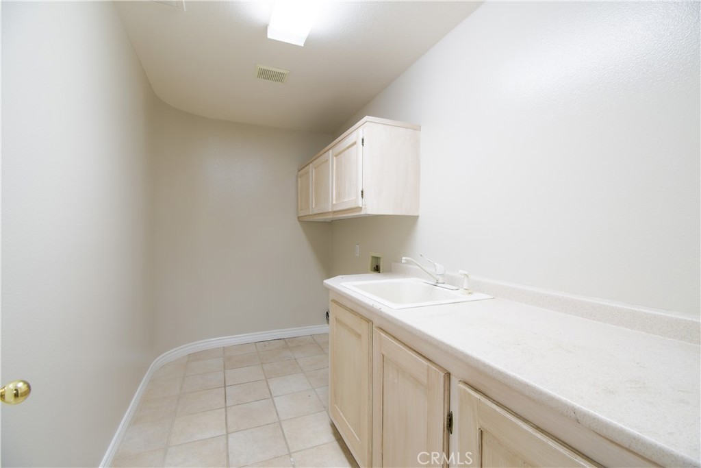 39705 Primrose Circle Murrieta, CA 92563 - Photo 18 of 31 a utility room with a sink a vanity and granite