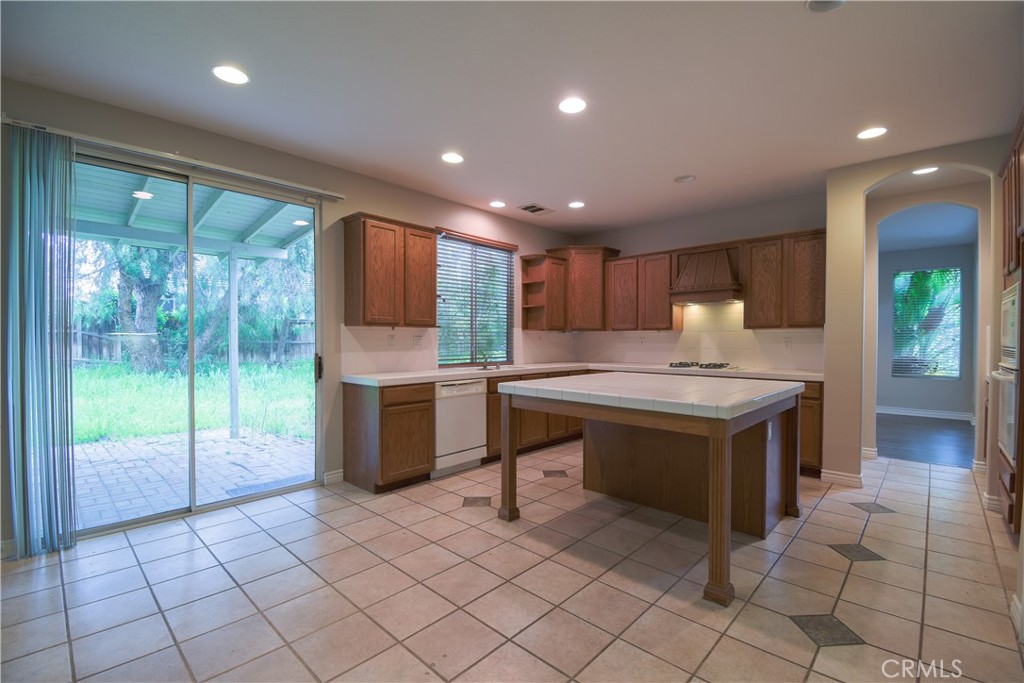 39705 Primrose Circle Murrieta, CA 92563 - Photo 8 of 31 a kitchen with kitchen island granite countertop a sink and a counter top space