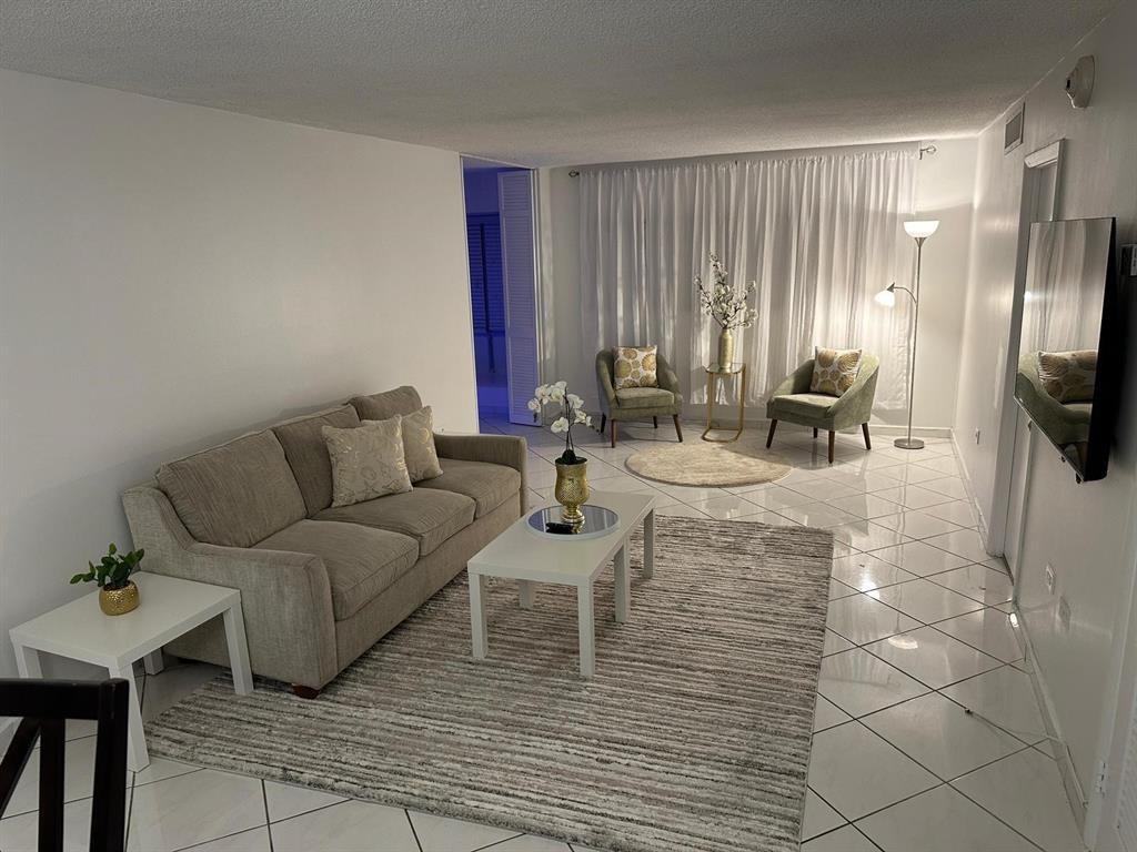 1881 Washington Avenue Miami Beach, FL 33139 - Photo 5 of 13 a living room with furniture and a flat screen tv