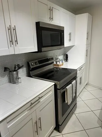 a kitchen with stainless steel appliances a stove a microwave a sink and cabinets