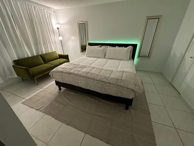 a bedroom with a bed couch and a window