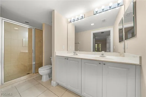 a bathroom with a double vanity sink mirror and toilet