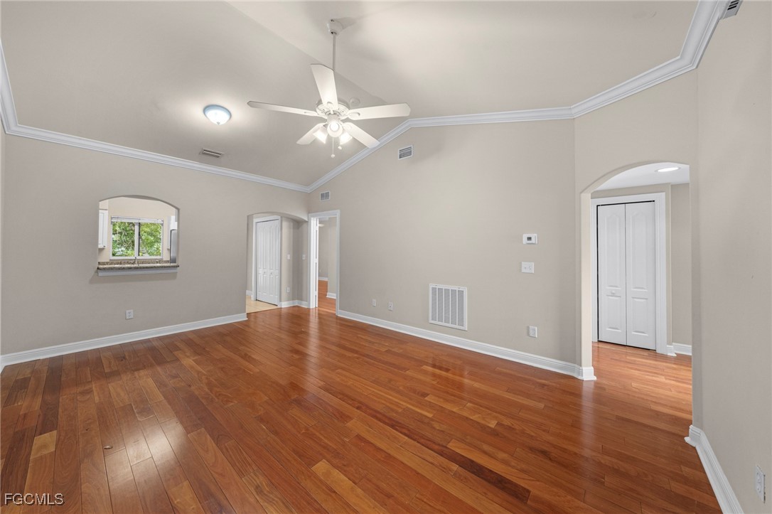 4172 Castilla Circle, Unit 201 Fort Myers, FL 33916 - Photo 2 of 34 an empty room with wooden floor chandelier fan and windows