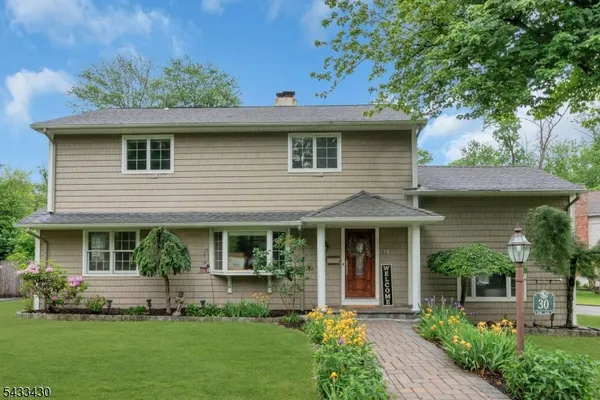 a front view of a house with a garden and plants