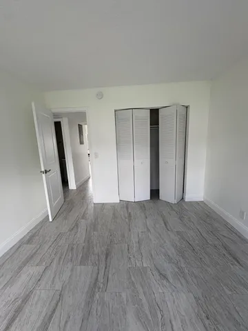 a view of empty room with wooden floor and fireplace