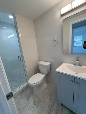 a bathroom with a toilet a sink and a mirror
