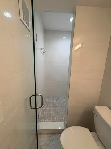 a bathroom with a toilet and a shower