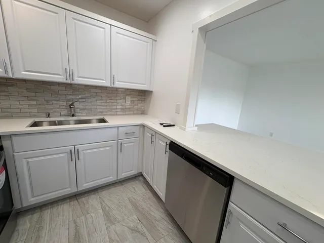 a kitchen with a sink dishwasher and cabinets