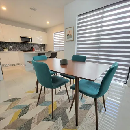 a kitchen with stainless steel appliances kitchen island granite countertop a stove and white cabinets