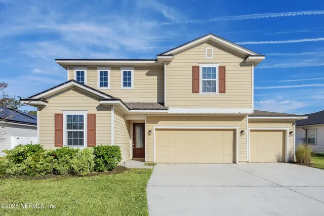 a front view of a house with a yard and garage