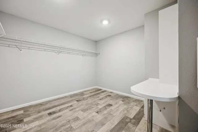 an empty room with ceiling fan and windows